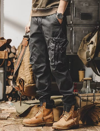 Black utility trousers with cargo pockets, drawstring waist, and button-flap details