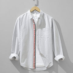 Men's blue striped linen shirt, front view with chest pocket and button placket trim