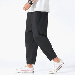 Black cropped cotton pants with drawstring waist and relaxed straight legs