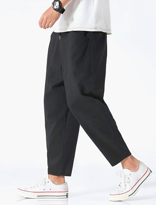 Black cropped cotton pants with drawstring waist and relaxed straight legs