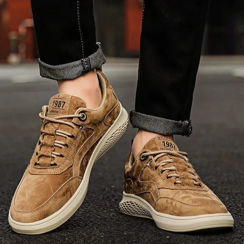 Tan suede lace-up sneakers with lace eyelets and white rubber cupsole, on feet