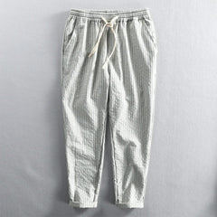 Light striped linen pants in white and gray with elastic waistband and drawstring
