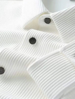 White business shirt fabric close-up with black buttons and pleated texture