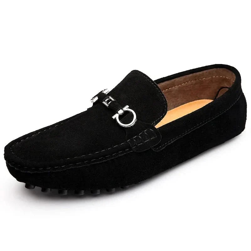 Black suede loafers with silver buckle strap detail and low rubber sole