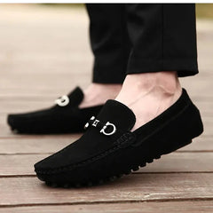 Black suede loafers with silver buckle hardware and textured rubber outsole