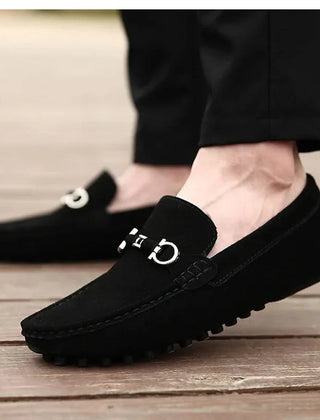 Black suede loafers with silver buckle hardware and textured rubber outsole