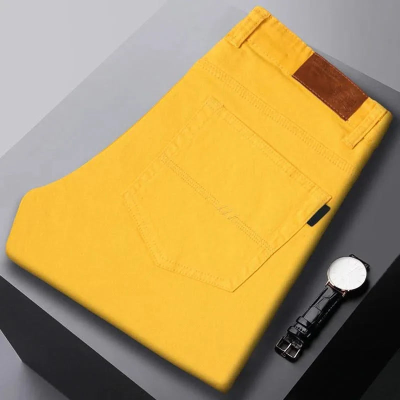 Yellow denim jeans folded flat, visible front pocket and brown leather logo patch