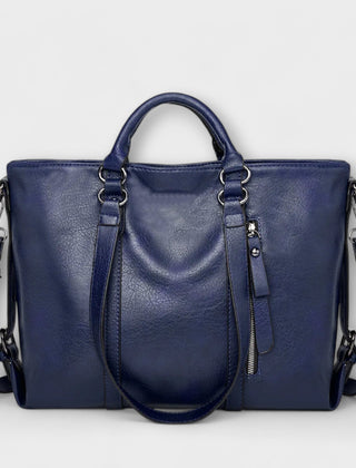 Blue leather handbag with top handles, shoulder straps, and zip pocket detail