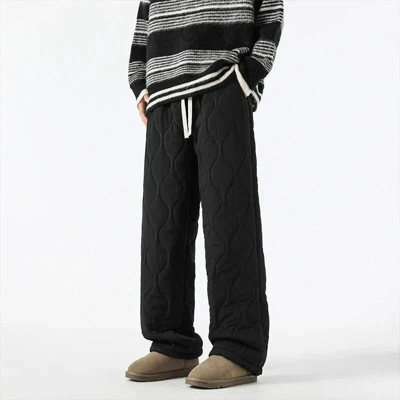 Black quilted pants with raised oval texture and drawstring waist, relaxed fit.
