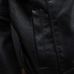 Black leather jacket close-up of vertical panel seams and snap placket.