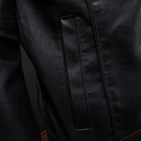 Black leather jacket close-up of vertical panel seams and snap placket.