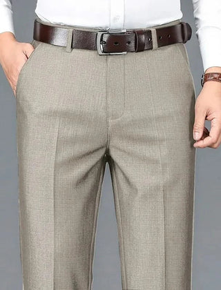 Beige dress trousers with belt loops, zip fly, and front crease detailing.