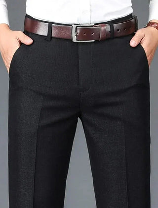 Black dress trousers with belt loops, zip fly, and straight slim fit legs.