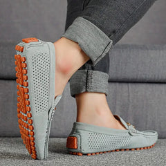 Light gray perforated leather loafer with metal bar detail and orange tread