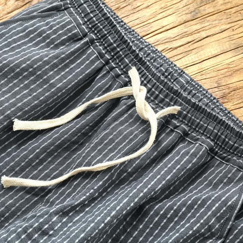 Striped linen pants waistband close-up with elastic, drawstring ties, and ribbed hem