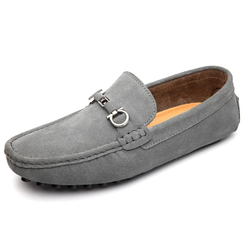 Light gray suede loafers with silver buckle ornament and textured rubber outsole