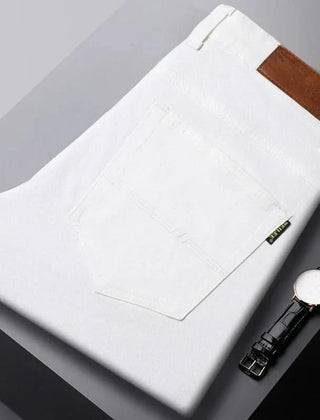 White denim jeans folded flat, visible front pocket and brown leather logo patch