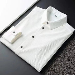 White business shirt folded flat, spread collar and button placket visible