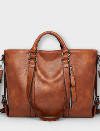 Brown large leather handbag with top handles, side straps, and zip pocket detail