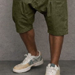 Army green casual drop-fit shorts close-up, button placket and cargo-style pockets.