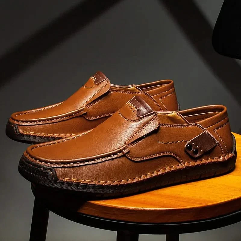 Tan leather slip-on loafer with moc-style stitching and metal bit