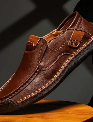Dark brown leather slip-on loafer with metal bit ornament and contrast stitching