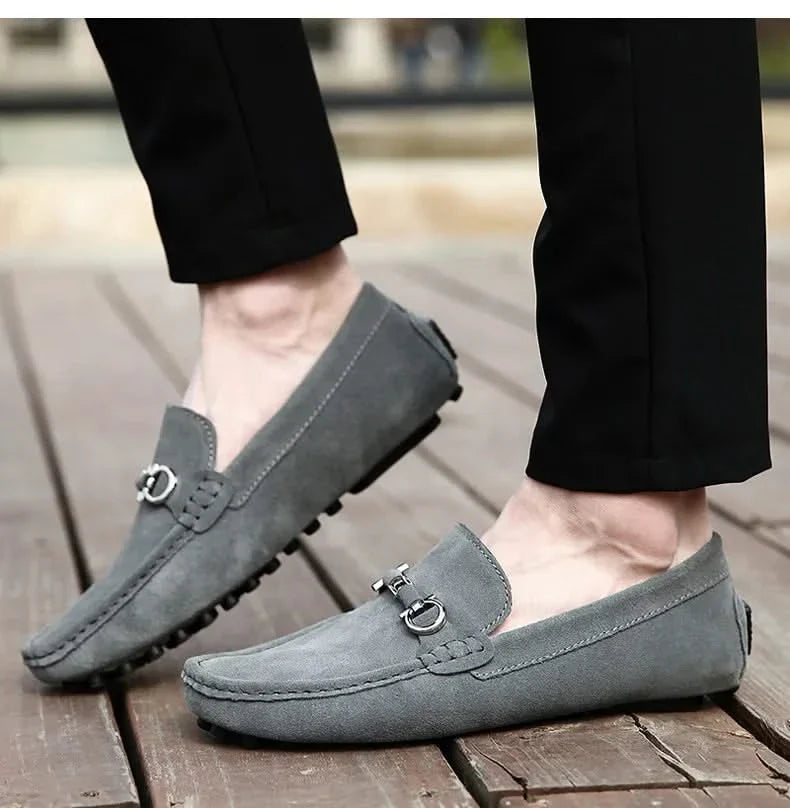 Gray suede loafers with silver buckle hardware and rubber tread sole