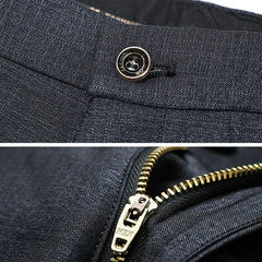 Dark textured trouser fabric detail with metal button and zipper closure.