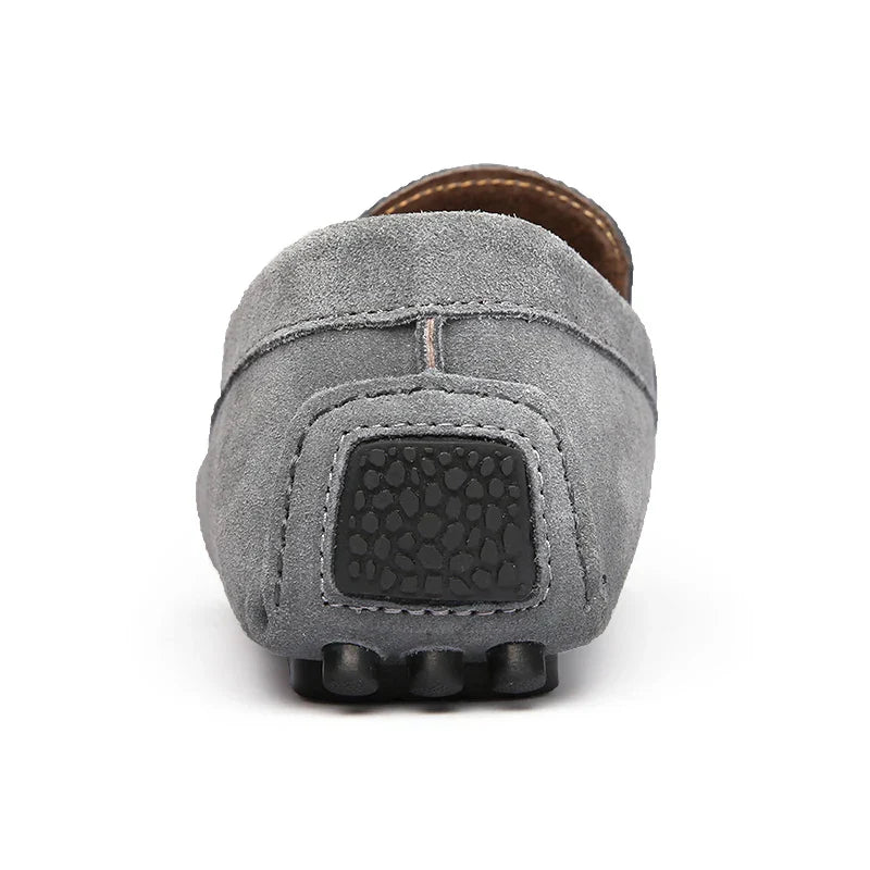 Gray suede loafer heel view with embossed logo panel and rubber nubs sole