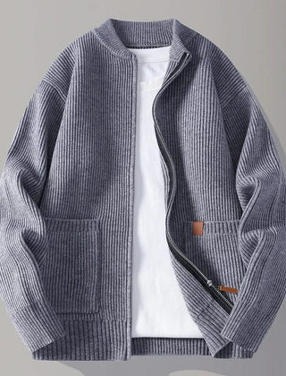 Slate blue rib knit zip-up jacket with stand collar, front pockets, and tan logo patch