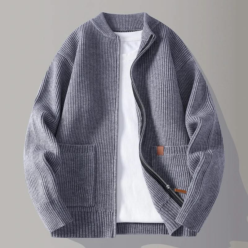 Slate blue rib knit zip-up jacket with stand collar, front pockets, and tan logo patch