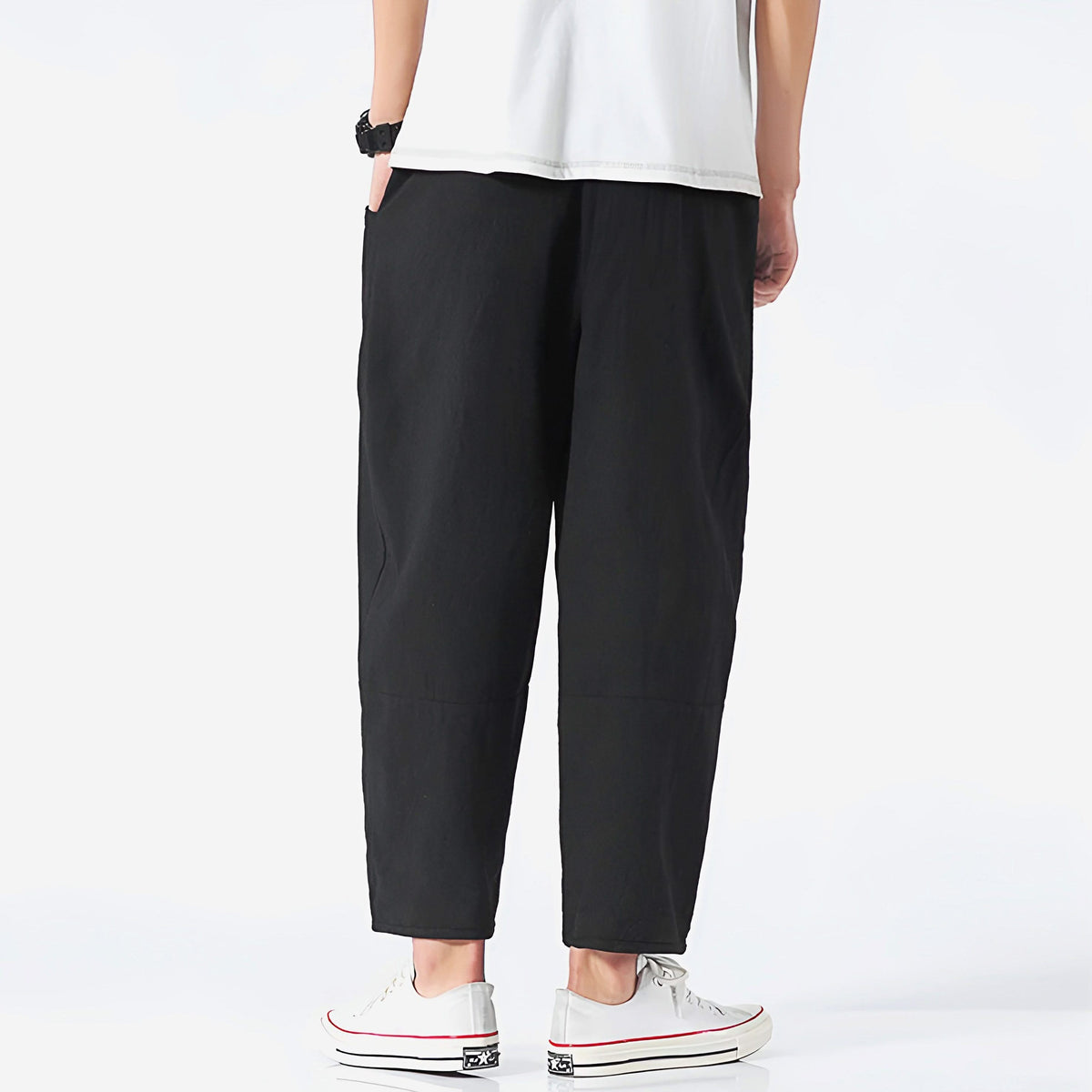 Black cropped cotton pants, back view with elastic waist and cuffed hems