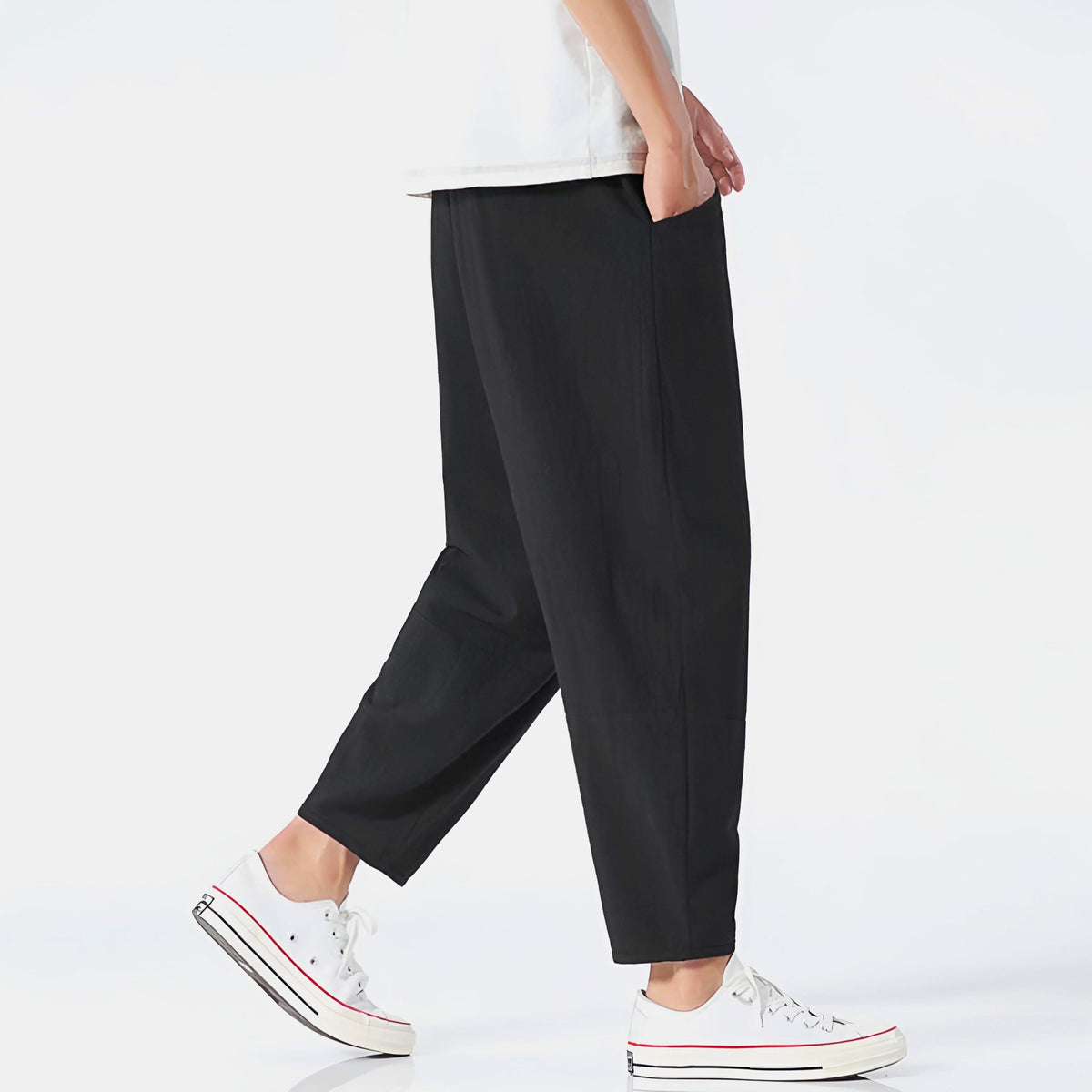 Black cropped cotton pants, side view with relaxed fit and zip pocket detail