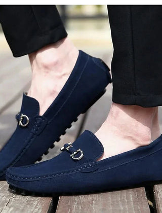 Blue suede loafers with silver buckle hardware and lugged rubber outsole
