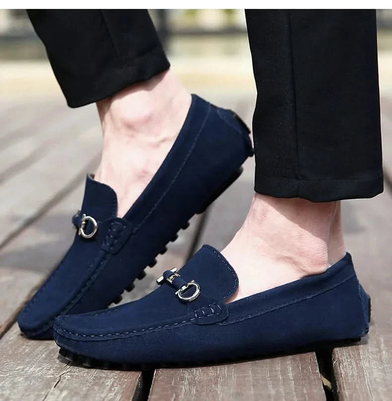 Blue suede loafers with silver buckle hardware and lugged rubber outsole
