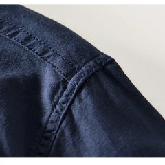 Navy linen shirt fabric close-up with stitched placket and seam detail