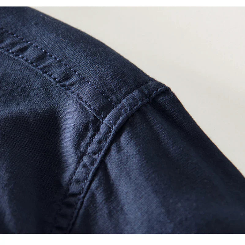 Navy linen shirt fabric close-up with stitched placket and seam detail