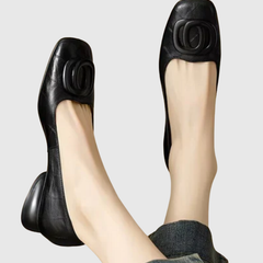 Black leather flats with oval buckle detail and low round toe