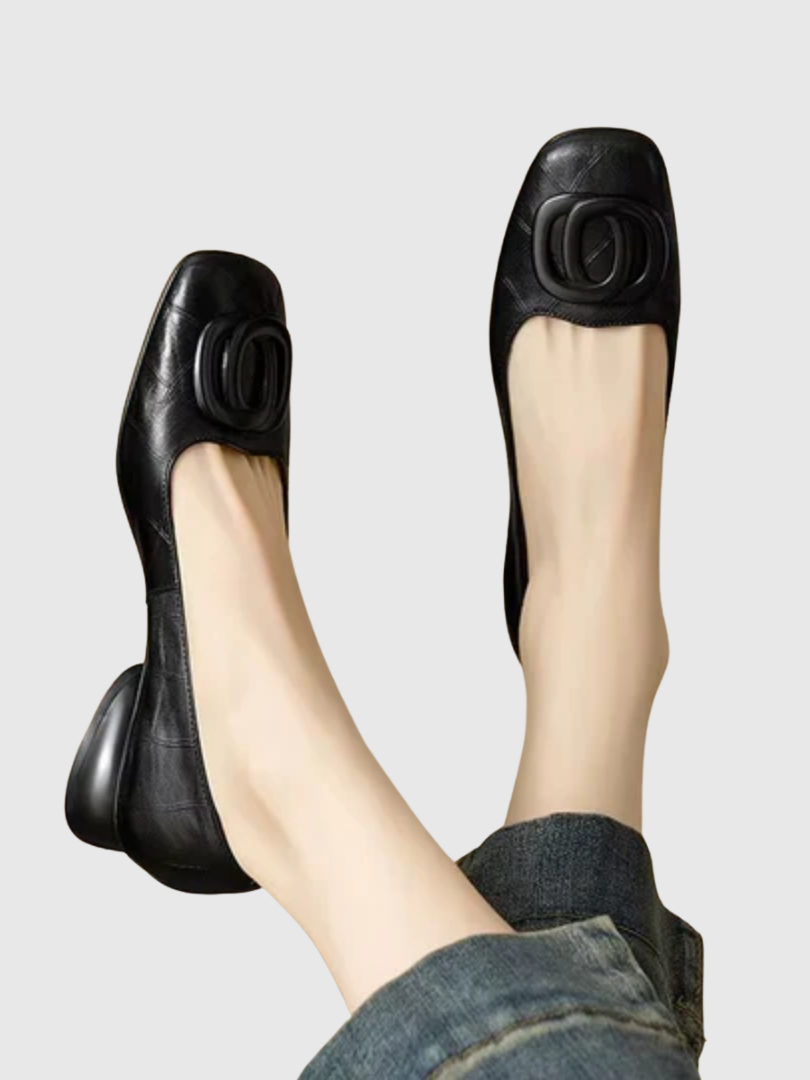 Black leather flats with oval buckle detail and low round toe