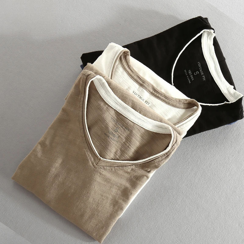 Folded cotton shirts with V-neck collars in beige, white, and black