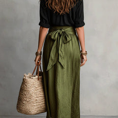 Two-piece set: back of black blouse with olive green midi skirt and bow