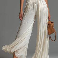 White pleated chiffon halter jumpsuit with deep V front and flowing wide-leg pants