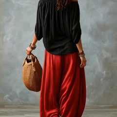 Black off-shoulder top with red lantern trousers, back view