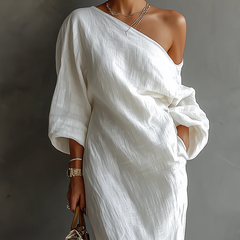 White one-shoulder maxi dress with draped sash waist and flowing off-shoulder sleeve