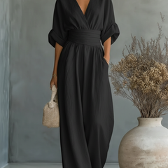Black V-neck high-waisted jumpsuit with wrap-style top and flowing wide-leg fit