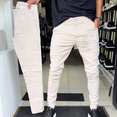 Off-white slim trousers with tapered legs, button waist, and side pockets