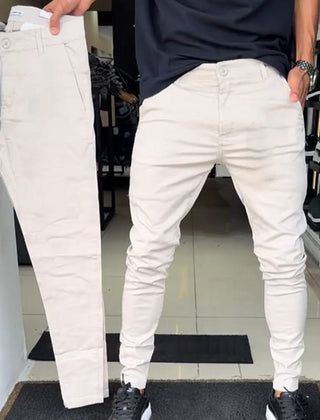 Off-white slim trousers with tapered legs, button waist, and side pockets