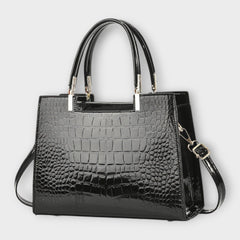 Shiny crocodile-pattern handbag in dark black with top handles and crossbody strap