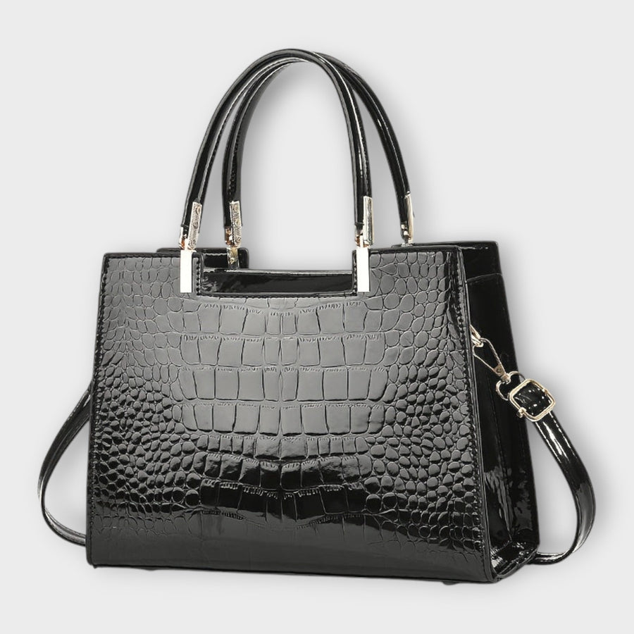 Shiny crocodile-pattern handbag in dark black with top handles and crossbody strap