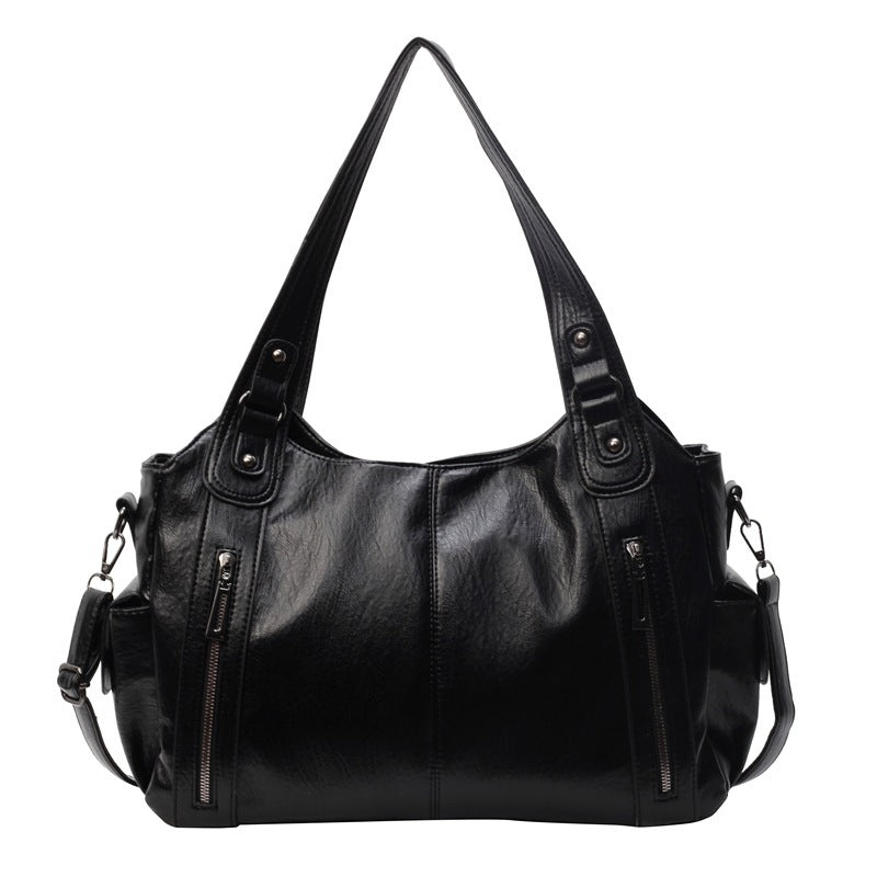 Black leather hobo handbag with dual handles, side zippers, and crossbody shoulder strap